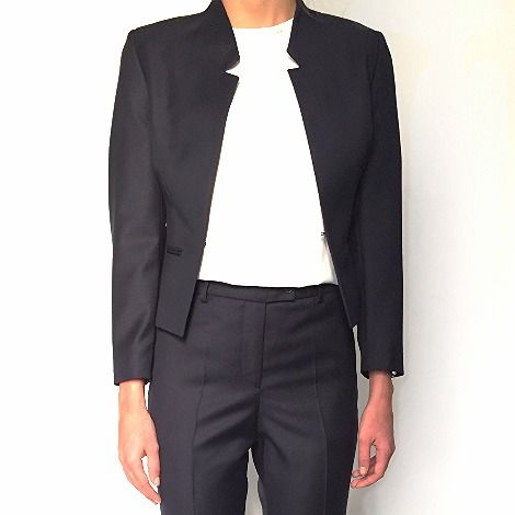 Tenue de vente : veste courte bleu marine et pantalon assorti sur haut blanc